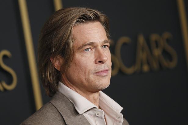 Porträt von Brad Pitt vor einem dunklen Hintergrund mit goldenen Buchstaben.