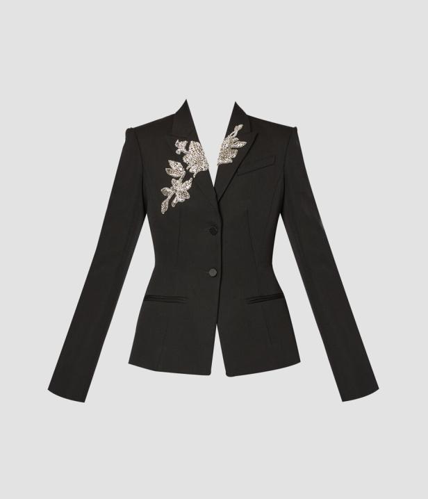Ein schwarzer Blazer mit floralen Applikationen aus Strasssteinen.