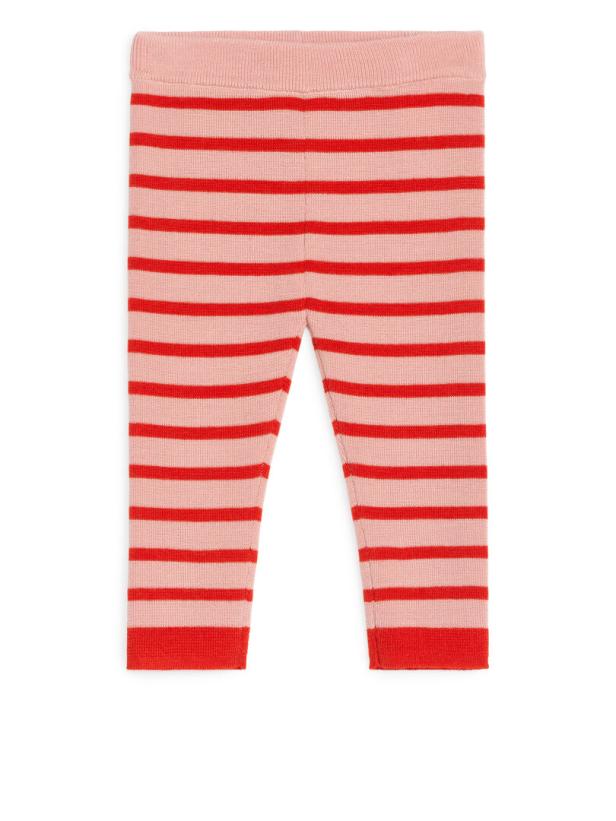 Eine gestreifte Leggings in Rosa und Rot liegt auf einem weißen Hintergrund.