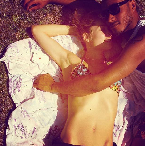 Ein Paar liegt auf einer Decke im Gras, die Frau im Bikini.