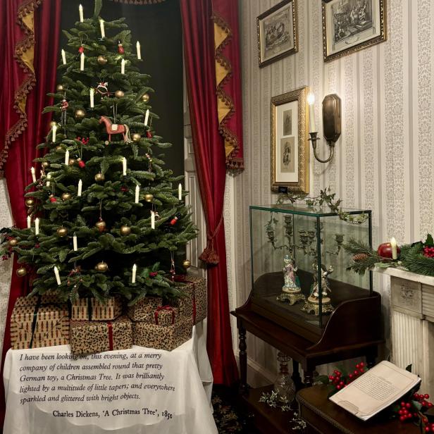 Ein geschmückter Weihnachtsbaum mit Geschenken in einem eleganten Zimmer.