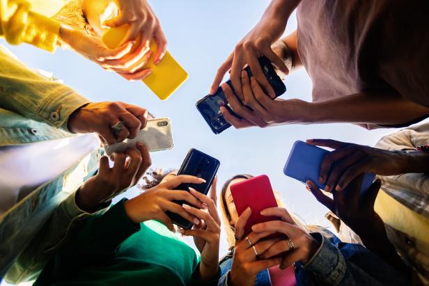 Eine Gruppe von Menschen hält ihre Smartphones in einem Kreis zusammen.