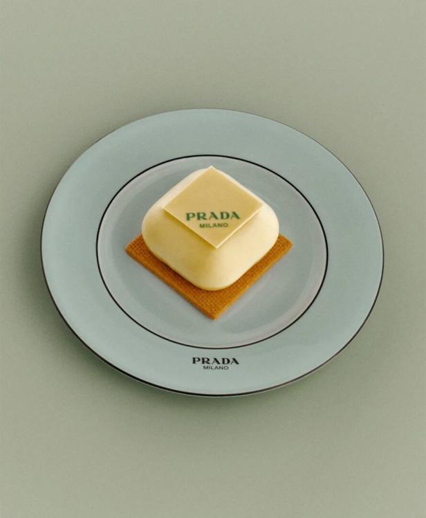 Ein Dessert mit dem Prada-Logo auf einem hellblauen Teller.
