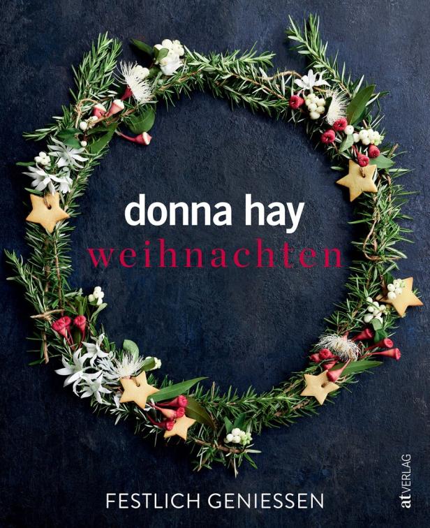 Ein Weihnachtskranz mit Sternen, Blumen und Beeren auf dunklem Hintergrund.