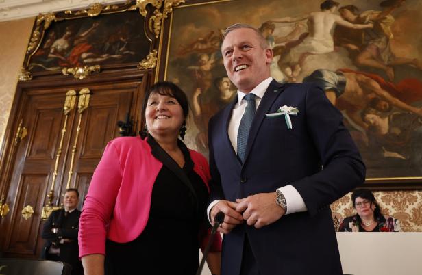 Manuela Khom und Mario Kunasek stehen lächelnd vor einem Gemälde.