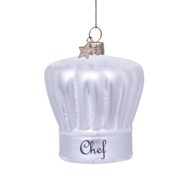 Ein weißer Kochmützen-Weihnachtsbaumschmuck hängt an einem Faden.