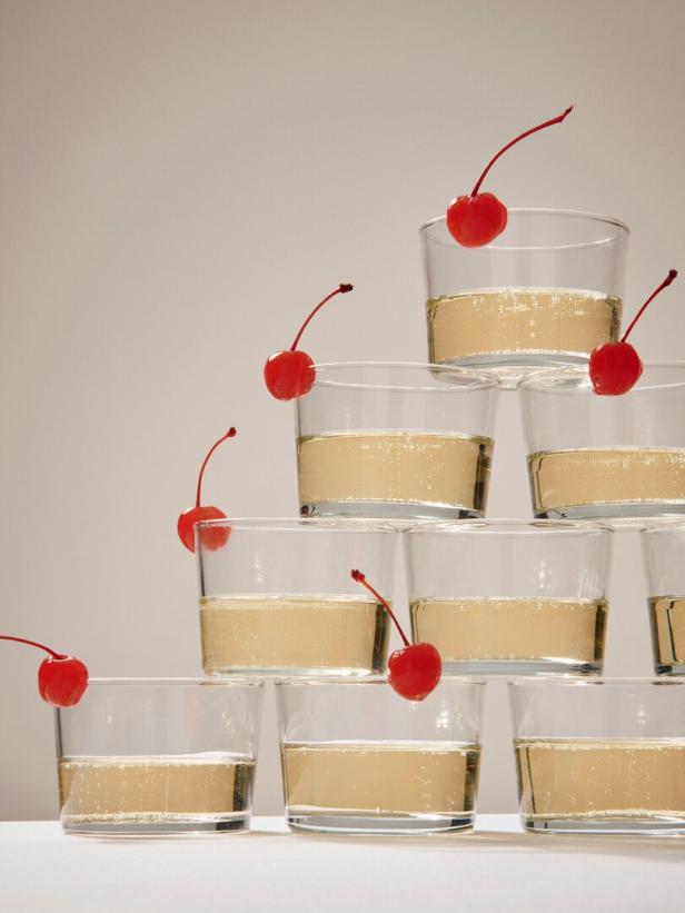 Eine Pyramide aus Sektgläsern, dekoriert mit Cocktailkirschen.