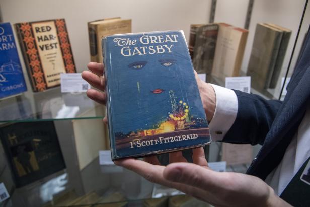 Eine Person hält eine Ausgabe von F. Scott Fitzgeralds „Der große Gatsby“ in den Händen.