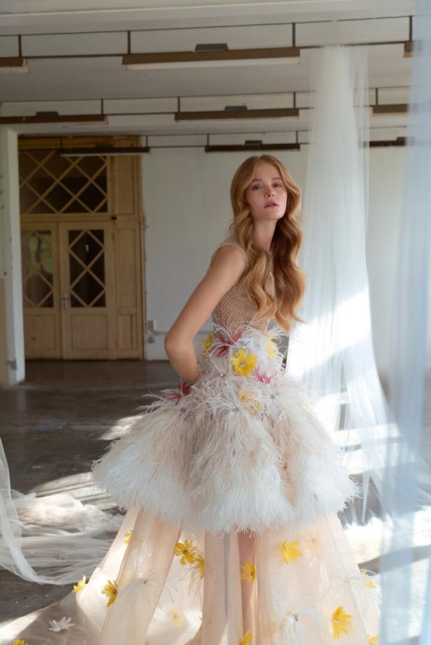 Eine Frau in einem extravaganten Kleid mit Federn und Blumen.