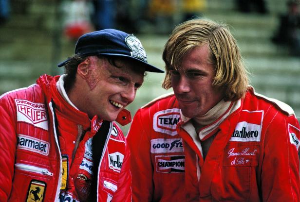 Niki Lauda und James Hunt in ihren Rennanzügen, die Sponsorenlogos tragen.