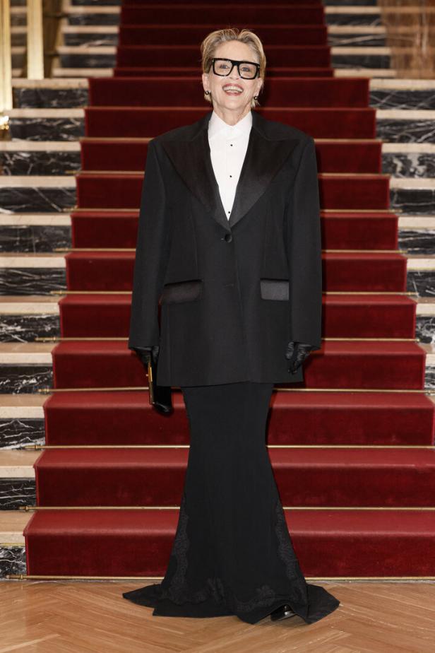 Sharon Stone auf einer Treppe in einem schwarzen Hosenanzug.