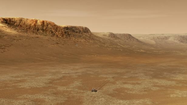 Eine riesige Felsenschlucht. Am Boden fährt der Rover.