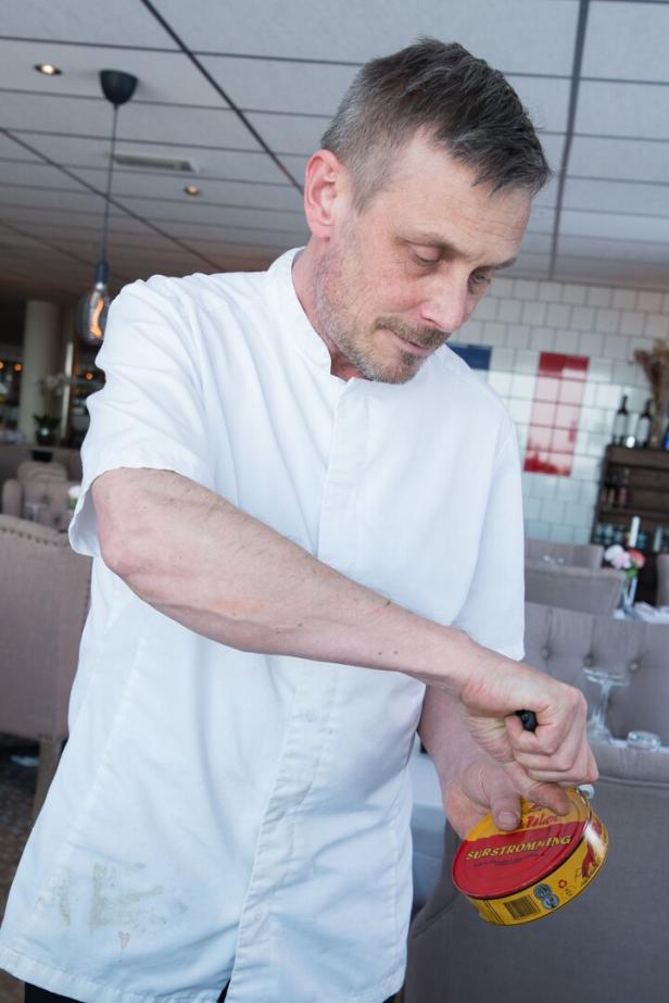 Koch Johan Kindberg öffnet eine Dose mit fermentiertem Hering - Surströmming