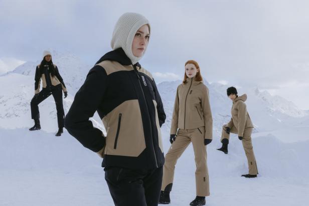 Vier Models präsentieren Winterkleidung der Marke Colmar in einer verschneiten Berglandschaft.