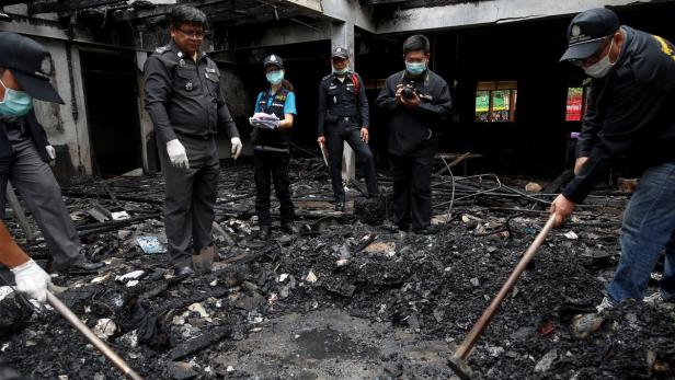 Forensic exports inspect a burnt building at the P