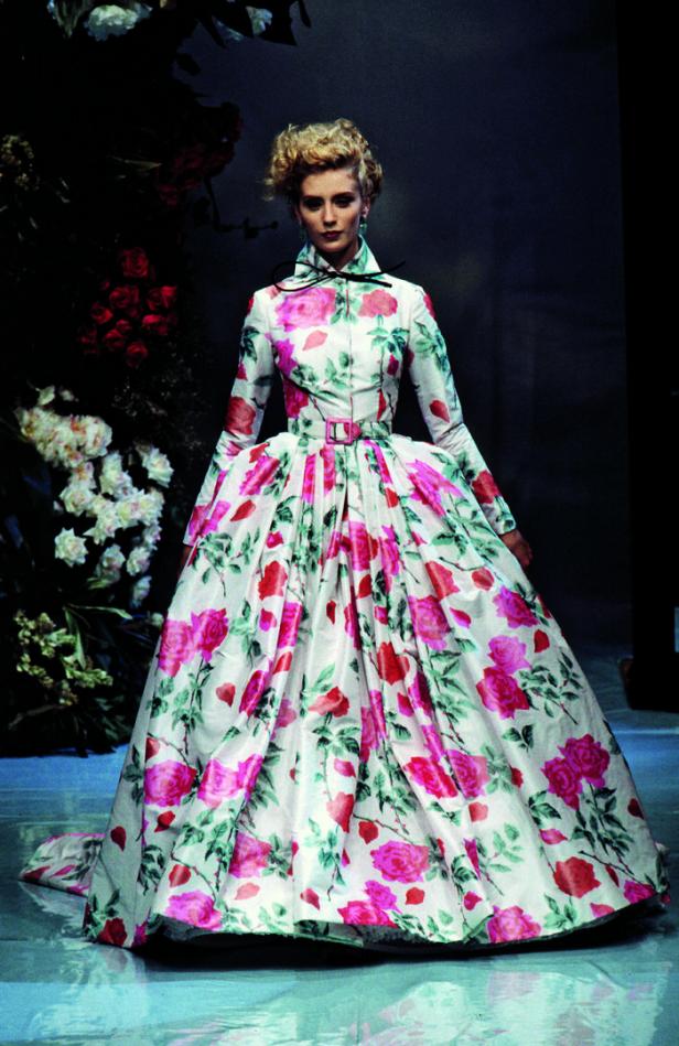 Eine Frau in einem langen, blumengemusterten Kleid auf einem Laufsteg.