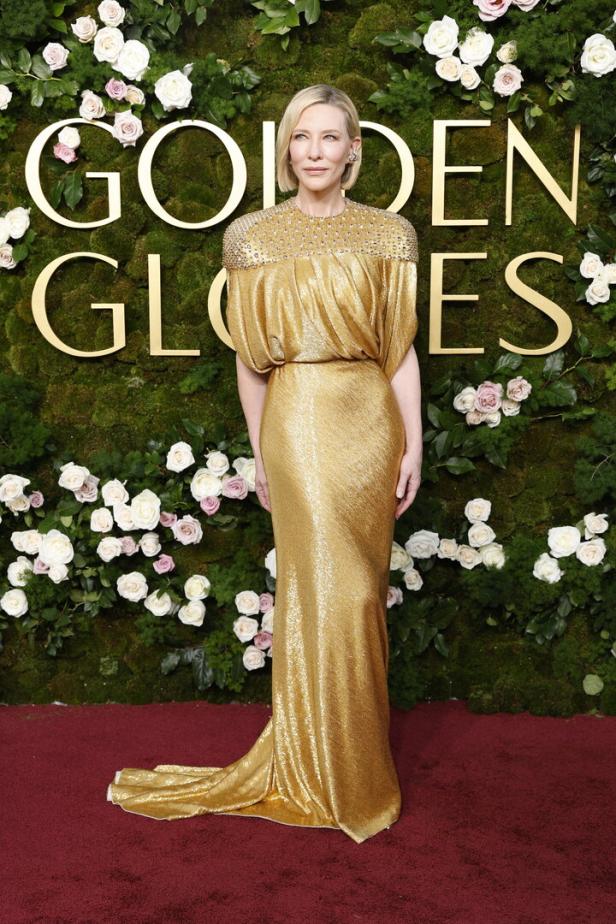 Cate Blanchett in einem goldenen Kleid vor einer Wand aus Blumen und dem Golden-Globes-Schriftzug.