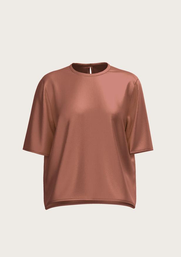 Ein rosafarbenes, glänzendes T-Shirt vor einem hellen Hintergrund.