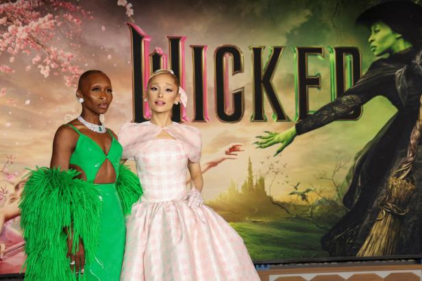 Cynthia Erivo und Ariana Grande posieren vor dem „Wicked“-Filmposter.