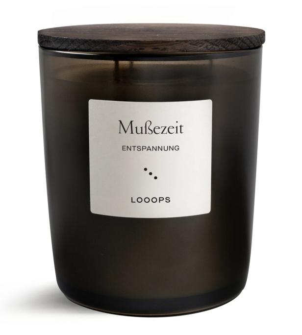 Eine Duftkerze mit der Aufschrift „Mußezeit. Entspannung“ und einem Holzdeckel.