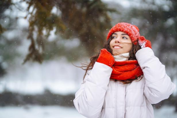 Frau mit Schal und Mantel beim winterlichen Spaziergang.