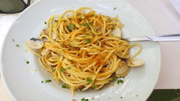 Ein Teller Spaghetti alle Vongole mit Petersilie und gerösteten Semmelbröseln.