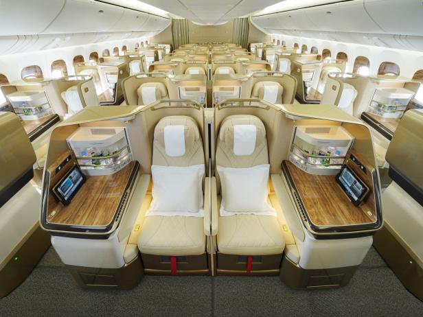 Innenansicht der luxuriösen Business Class eines Flugzeugs mit Sitzen und Annehmlichkeiten.