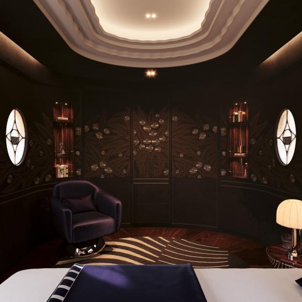Ein luxuriöses Schlafzimmer mit dunklen Wänden und einem lila Sessel.