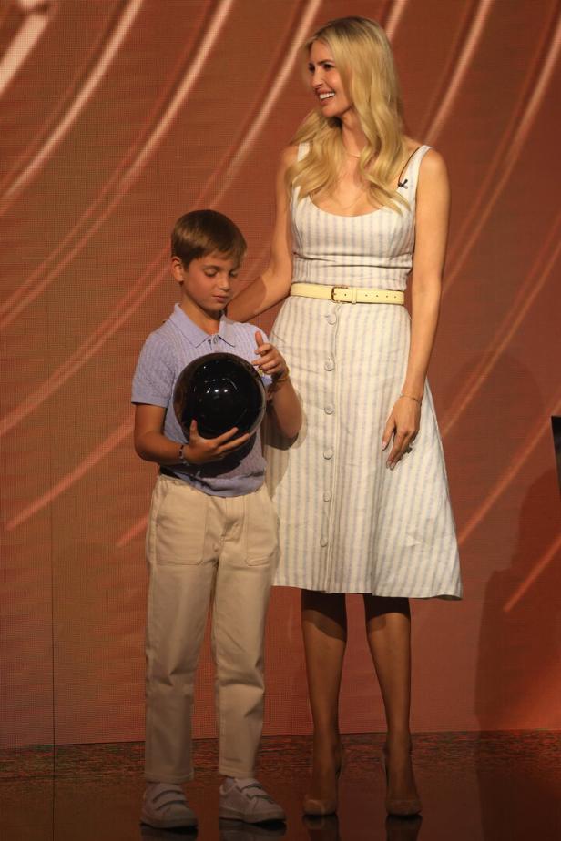 Ivanka Trump steht mit einem Jungen, der einen schwarzen Ball hält.