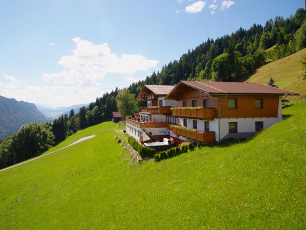 Der Bergbauernhof Irxner liegt auf einer grünen Wiese am Hang.