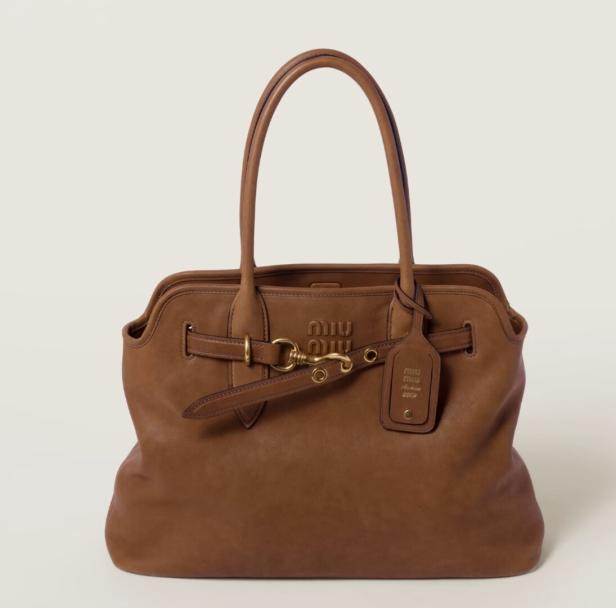 Eine braune Miu Miu Handtasche mit goldenen Akzenten und einem Anhänger.