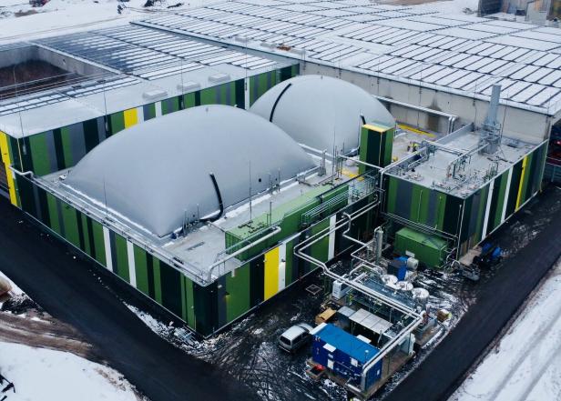 Eine Biogasanlage mit zwei großen, grauen Kuppeln im Winter.
