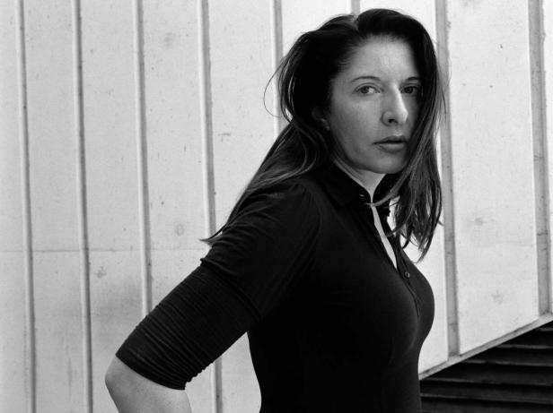 Schwarzweißporträt der Künstlerin Marina Abramović vor einer Wand.