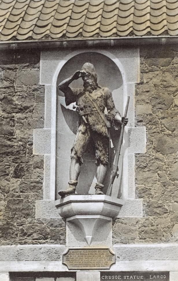 Eine Statue von Robinson Crusoe mit Gewehr steht in einer Mauernische.