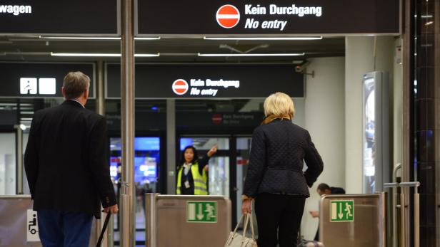 Ein Mann und eine Frau gehen durch einen Eingang mit der Aufschrift „Kein Durchgang“.