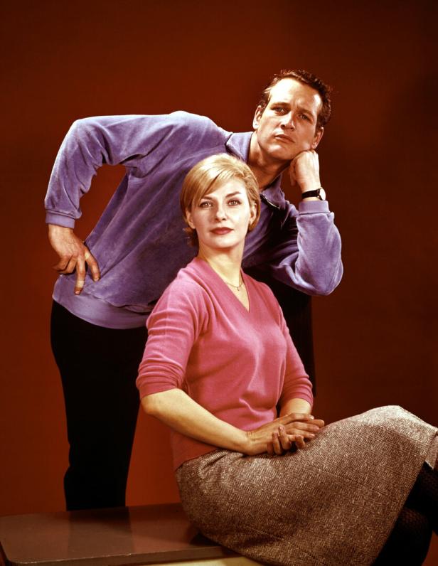 Paul Newman posiert mit seiner Frau Joanne Woodward vor einem braunen Hintergrund.