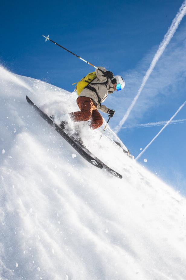 Ein Skifahrer fährt auf einer schneebedeckten Piste Ski.