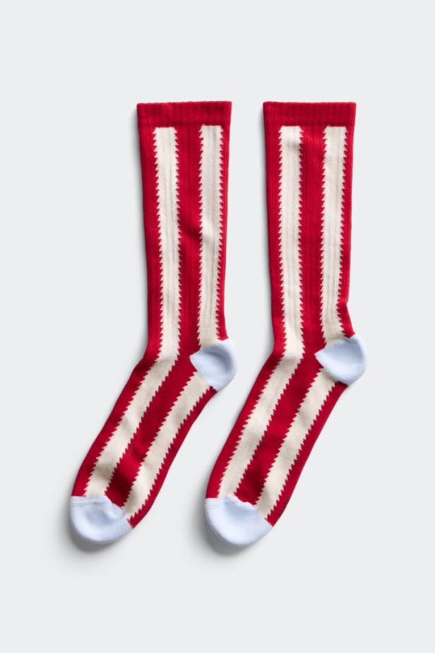 Zwei rot-weiß gestreifte Socken mit hellblauen Spitzen liegen auf einem weißen Hintergrund.