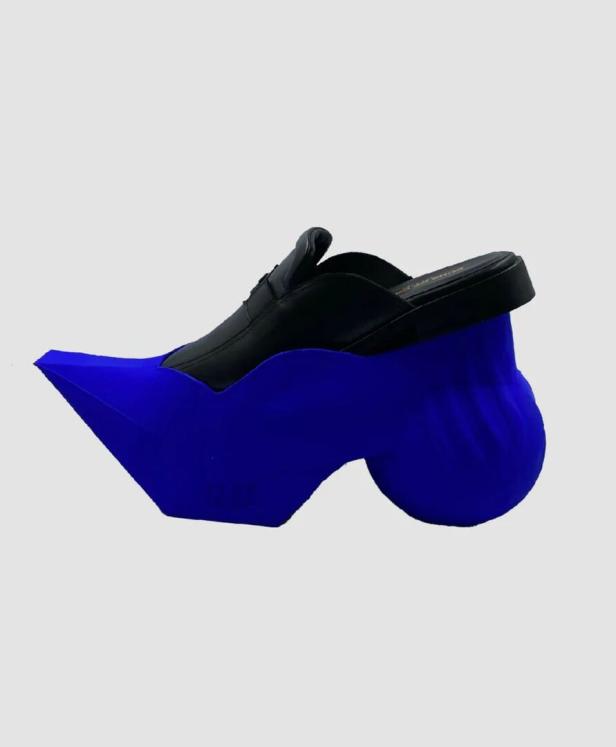Ein schwarzer Slipper mit einer auffälligen, blauen Sohle.