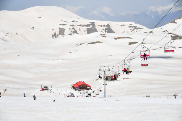 Ein Sessellift in einer eingeschneiten Landschaft.