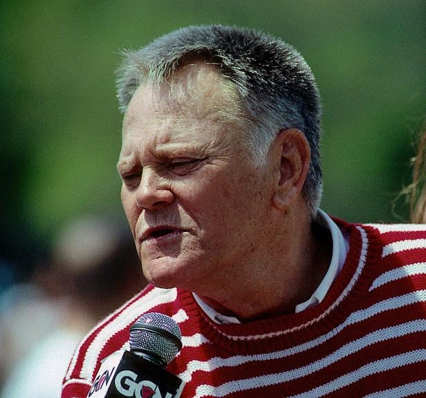 Ein Mann mit rot-weiß gestreiftem Pullover spricht in ein Mikrofon.