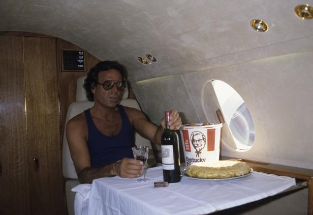 Julio Iglesias genießt Wein und Hähnchen in einem Privatjet.