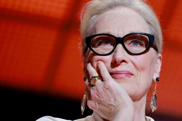 Meryl Streep mit Brille und goldenem Ring blickt nachdenklich nach oben.
