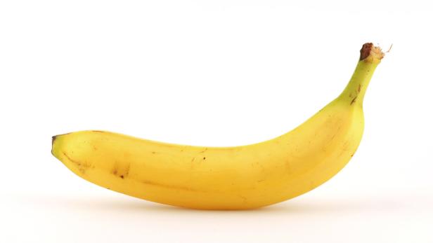 Eine einzelne gelbe Banane liegt vor einem weißen Hintergrund.
