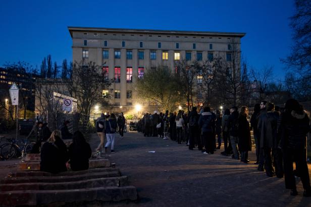 Menschen stehen vor dem Berghain in Berlin an. Es ist ein massives Gebäude - einst war darin ein Heizkraftwerk untergebracht.