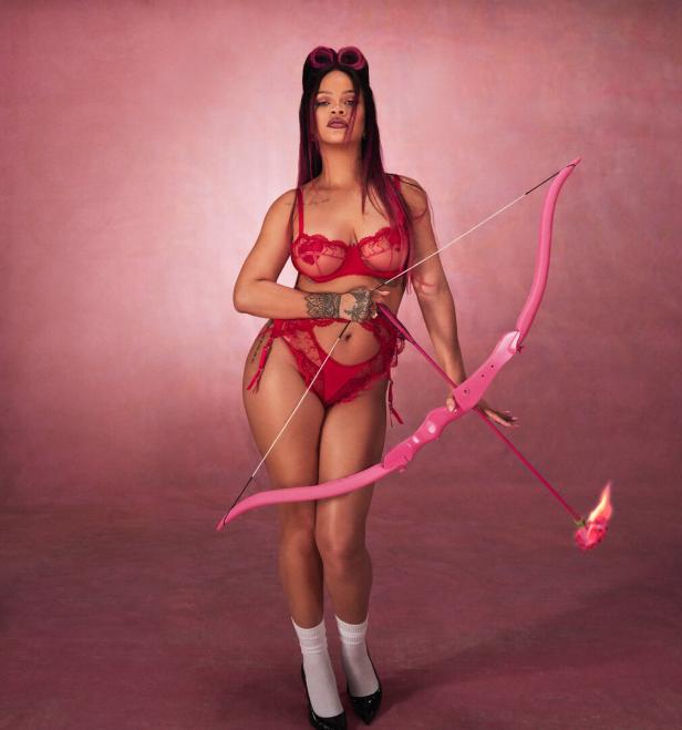 Sängerin Rihanna posiert in roter Dessous mit Pfeil und Bogen.