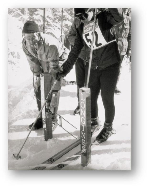 Zwei Skifahrer stehen im Schnee neben Longines-Markierungen.