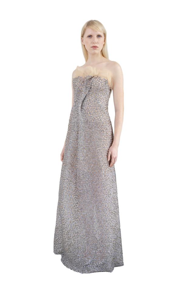 Eine Frau in einem langen, ärmellosen Kleid mit einem zarten, floralen Muster.
