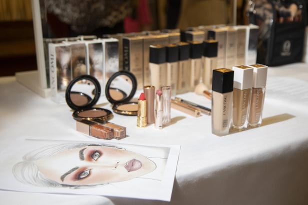 Eine Auswahl an Lancôme-Make-up-Produkten auf einem Tisch, darunter Foundation, Puder und Lippenstifte.