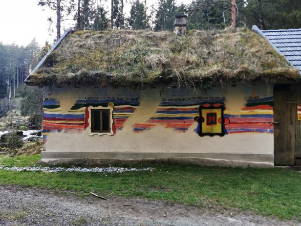 Die alte Hundertwasser-Mühle samt Grasdach zieren bunte Linien